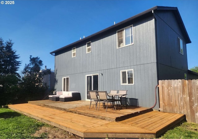 back of house featuring outdoor dining area, an outdoor living space, a wooden deck, and fence