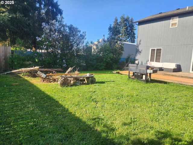 view of yard with fence, a wooden deck, and an outdoor living space