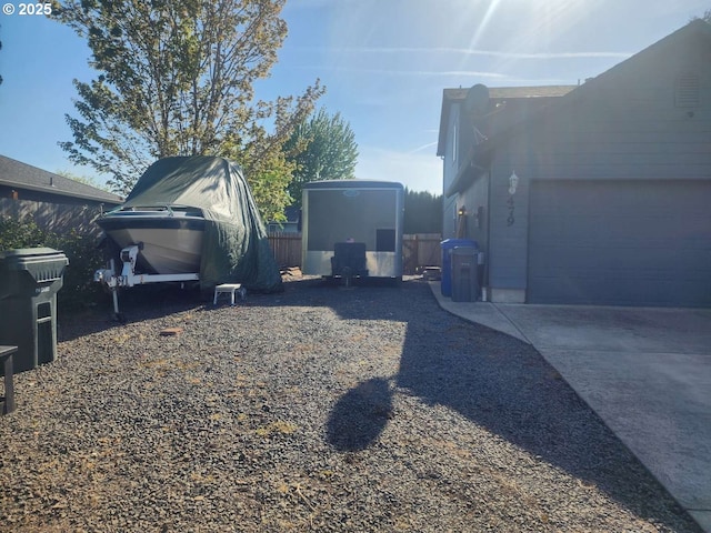view of yard with an attached garage and fence