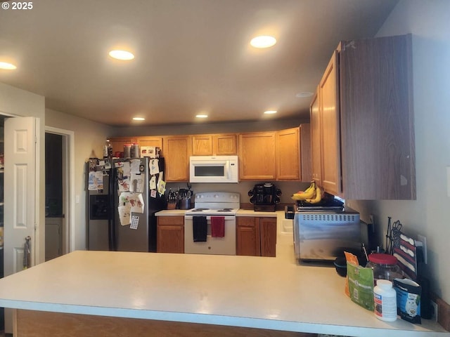kitchen featuring white appliances, a peninsula, recessed lighting, and light countertops