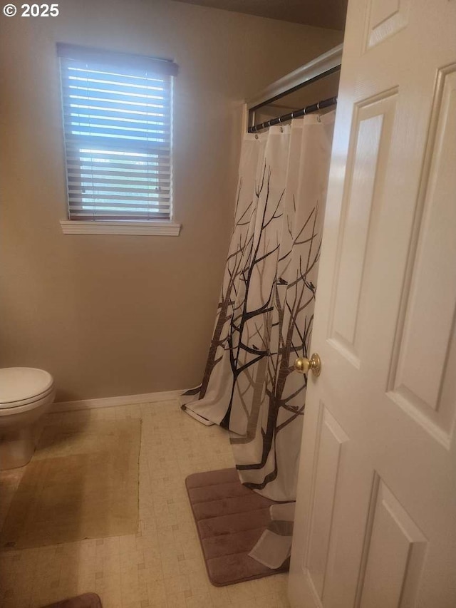 full bath featuring baseboards, a shower with shower curtain, tile patterned floors, and toilet