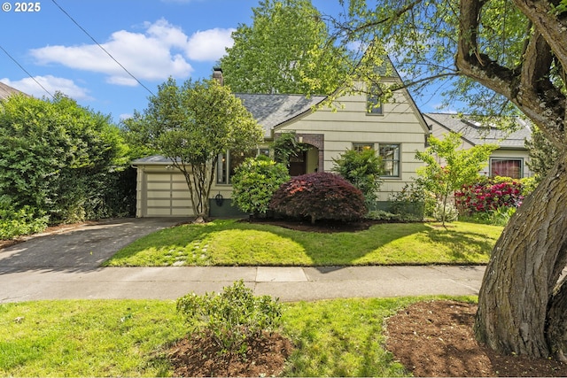 1710 SE 42nd Ave, Portland, OR 97215 - tudor home featuring asphalt driveway, an attached garage, a front yard, a chimney, and roof with shingles