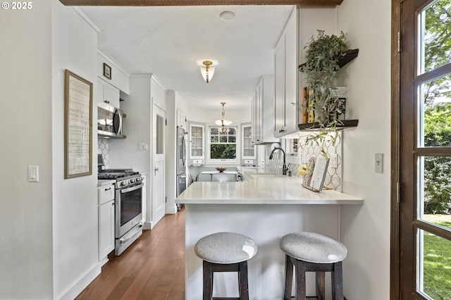 1710 SE 42nd Ave, Portland, OR 97215 - kitchen featuring appliances with stainless steel finishes, a sink, a peninsula, a breakfast bar, and backsplash