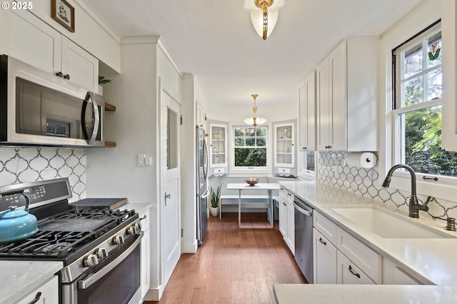 1710 SE 42nd Ave, Portland, OR 97215 - kitchen featuring appliances with stainless steel finishes, a sink, white cabinets, and backsplash