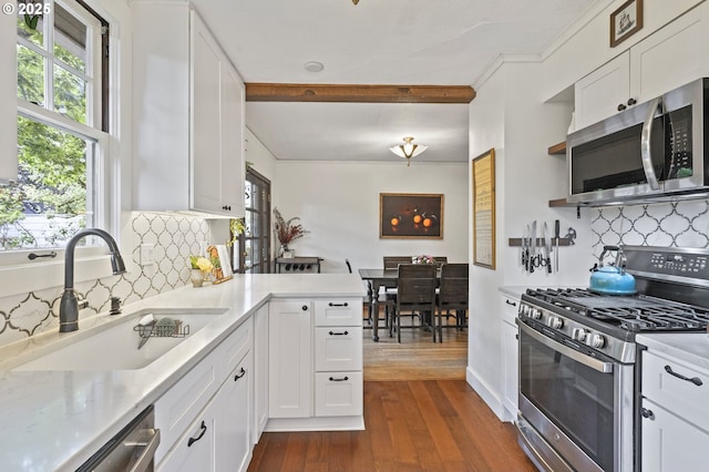 1710 SE 42nd Ave, Portland, OR 97215 - kitchen featuring appliances with stainless steel finishes, a sink, dark wood-style flooring, white cabinets, and ornamental molding
