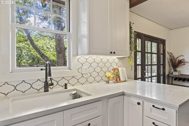 1710 SE 42nd Ave, Portland, OR 97215 - kitchen featuring a sink, backsplash, and white cabinets