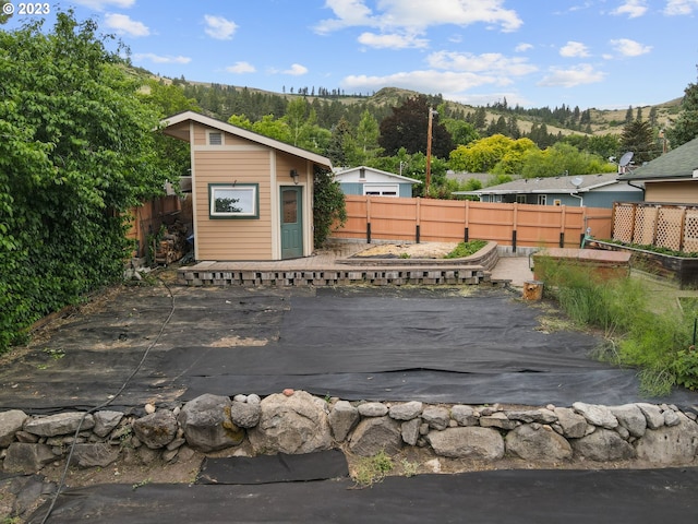 702 B Ave, La Grande, OR 97850 - wooden deck featuring an outdoor structure, a patio, a fenced backyard, a mountain view, and a storage shed