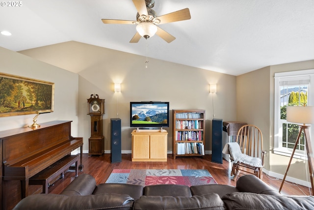 living area featuring lofted ceiling, ceiling fan, dark wood-style flooring, and baseboards