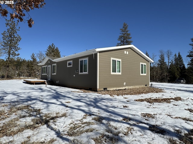 view of snow covered back of property