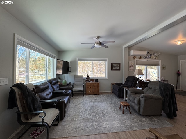 living room featuring a wall mounted AC, ceiling fan, and light hardwood / wood-style flooring