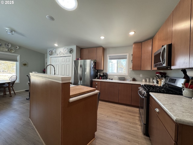 kitchen featuring light hardwood / wood-style flooring, stainless steel appliances, and a kitchen island