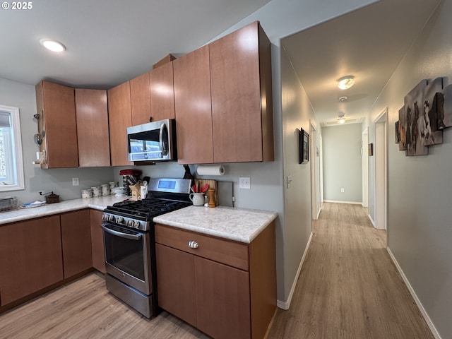 kitchen with stainless steel appliances and light hardwood / wood-style floors