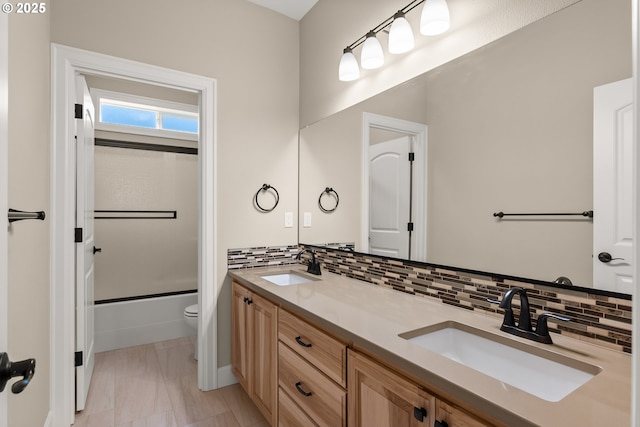 15430 NW Delia St, Portland, OR 97229 - bathroom featuring toilet, double vanity, backsplash, and shower / bath combination with glass door