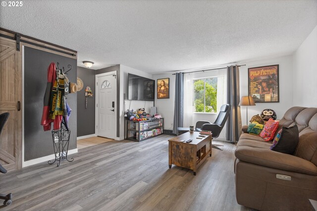 159 SW Florence Ave Unit J53, Gresham, OR 97080 - living area featuring a textured ceiling, wood finished floors, a barn door, and baseboards