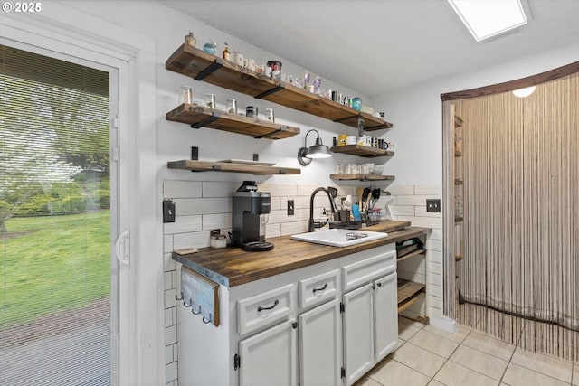 159 SW Florence Ave Unit J53, Gresham, OR 97080 - kitchen featuring open shelves, butcher block countertops, a sink, light tile patterned floors, and white cabinets