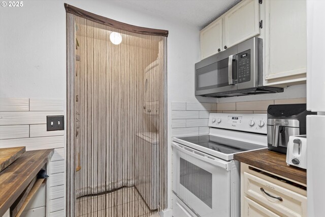 159 SW Florence Ave Unit J53, Gresham, OR 97080 - kitchen featuring electric range, stainless steel microwave, butcher block counters, tile walls, and backsplash