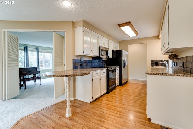 kitchen featuring decorative backsplash, white cabinets, appliances with stainless steel finishes, and a sink