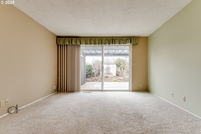 carpeted spare room with baseboards and a textured ceiling