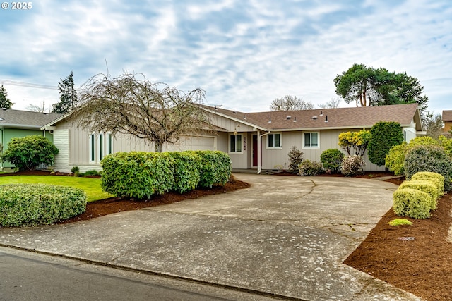 ranch-style house with a front yard, an attached garage, driveway, and roof with shingles