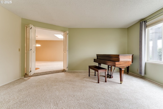 living area featuring baseboards, carpet floors, a textured ceiling, and an inviting chandelier