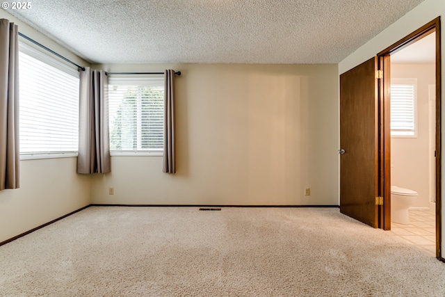 unfurnished room with visible vents, baseboards, and a textured ceiling