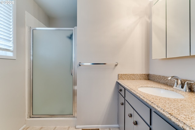 full bath with a stall shower and vanity