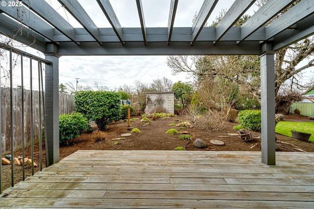 wooden deck featuring an outdoor structure, fence, and a pergola