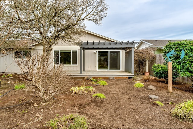 rear view of house with fence and board and batten siding