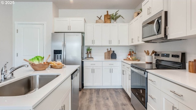3422 SW Hartley Ave, Gresham, OR 97080 - kitchen featuring appliances with stainless steel finishes, white cabinets, light countertops, and light wood-style floors