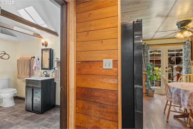 12785 Sutherland Rd, Swisshome, OR 97480 - interior space featuring vanity, a skylight, toilet, french doors, and a ceiling fan