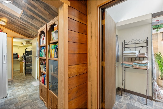 12785 Sutherland Rd, Swisshome, OR 97480 - corridor featuring stone finish flooring, vaulted ceiling, and baseboards