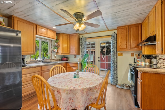 12785 Sutherland Rd, Swisshome, OR 97480 - kitchen with freestanding refrigerator, black range with electric cooktop, a ceiling fan, under cabinet range hood, and open shelves