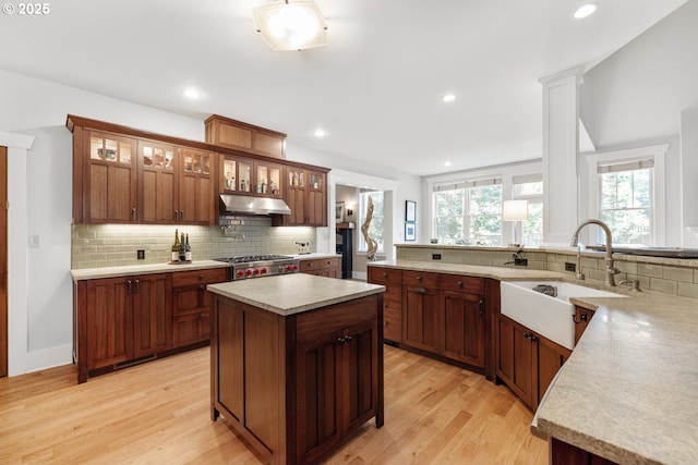 12624 SW 22nd Ave, Lake Oswego, OR 97034 - kitchen with under cabinet range hood, light countertops, backsplash, light wood finished floors, and recessed lighting