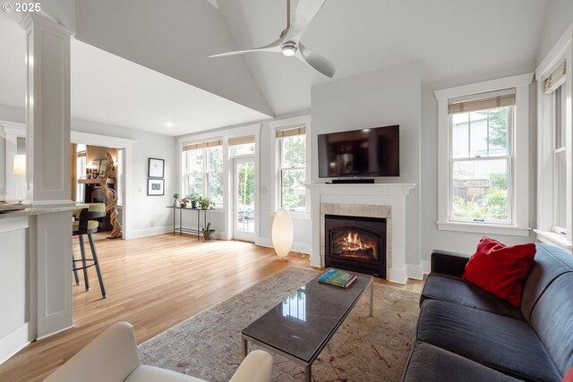 12624 SW 22nd Ave, Lake Oswego, OR 97034 - living area with a fireplace, a ceiling fan, light wood-style flooring, vaulted ceiling, and decorative columns