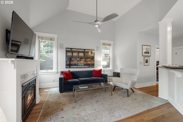12624 SW 22nd Ave, Lake Oswego, OR 97034 - living room featuring wood finished floors, a glass covered fireplace, ceiling fan, high vaulted ceiling, and ornate columns