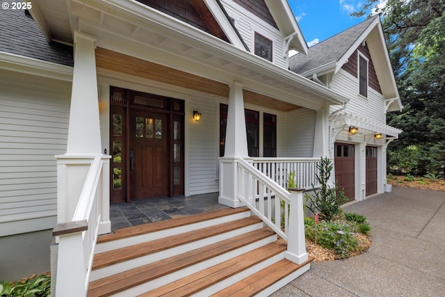 12624 SW 22nd Ave, Lake Oswego, OR 97034 - view of exterior entry with covered porch, driveway, a shingled roof, and a garage