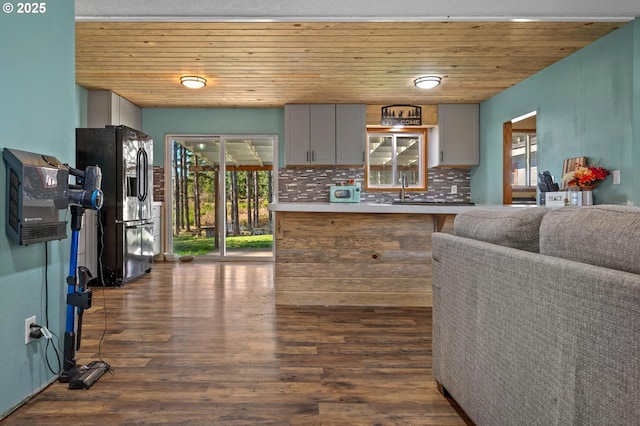 kitchen featuring wood ceiling, stainless steel fridge, backsplash, and dark wood-style flooring