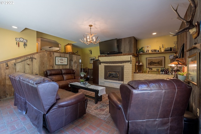 living room with a brick fireplace and an inviting chandelier