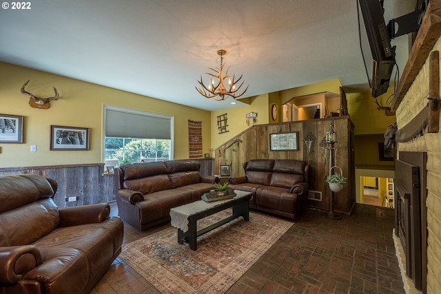 living room with a chandelier and wood walls