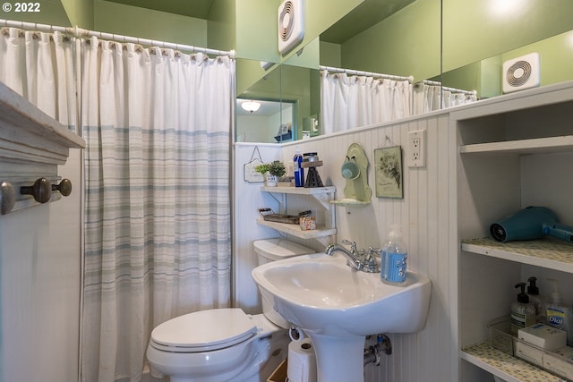 bathroom featuring shower / bathtub combination with curtain and toilet