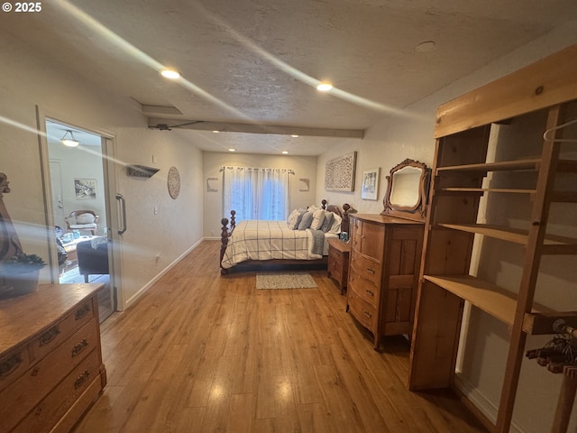 bedroom with a textured ceiling and light hardwood / wood-style floors