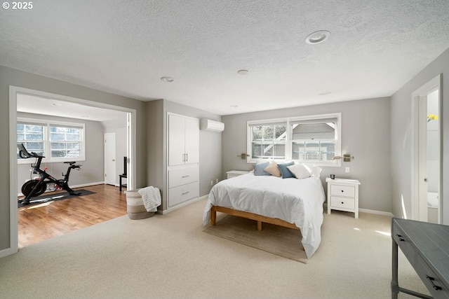 bedroom with a textured ceiling, light colored carpet, and multiple windows