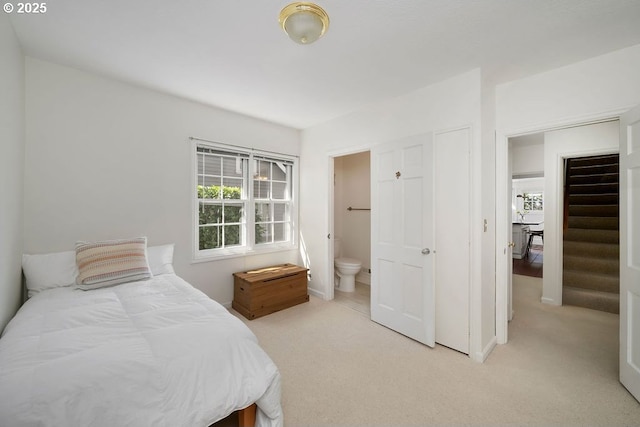 bedroom with light carpet and ensuite bath