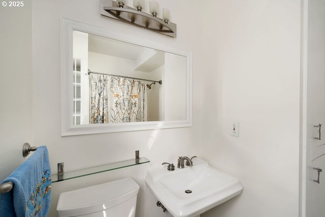 full bath featuring a sink, a shower with shower curtain, and toilet