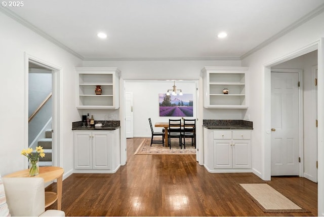 bar featuring dark wood-type flooring, stairs, ornamental molding, and recessed lighting