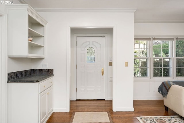 entrance foyer featuring baseboards, ornamental molding, and dark wood-type flooring