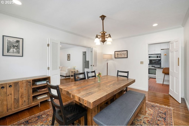 dining space featuring recessed lighting, wood finished floors, ornamental molding, and an inviting chandelier
