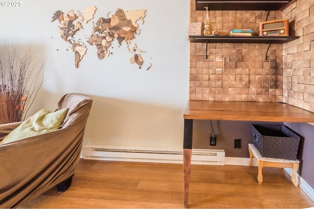 interior space with decorative backsplash, wood finished floors, and a baseboard radiator