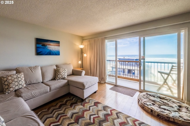 living room featuring a water view, wood finished floors, and a textured ceiling
