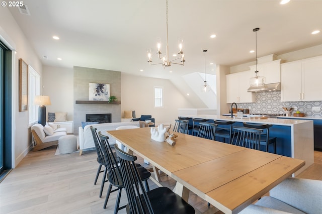 15174 SW 164th Ave Unit L12, Tigard, OR 97224 - dining room featuring light wood-style flooring, a fireplace, recessed lighting, baseboards, and a chandelier